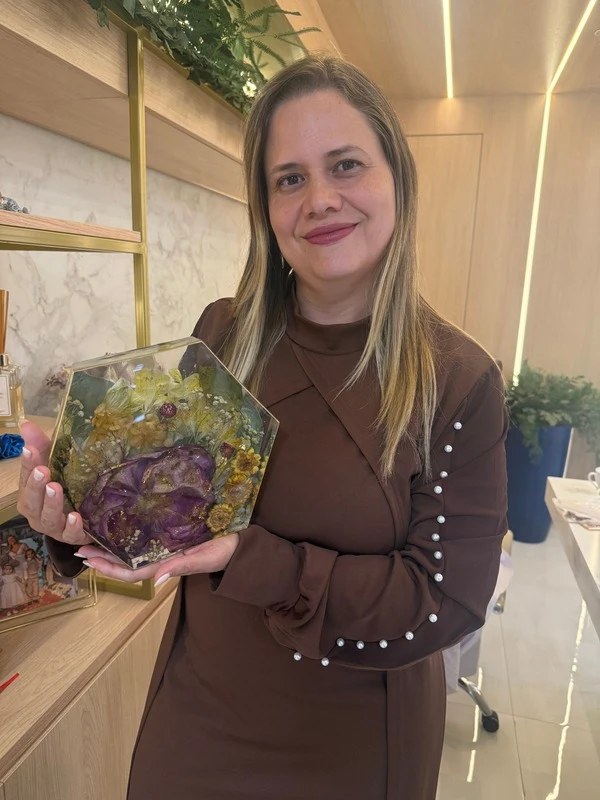 Renata C G Santiago, artesã da RS, segurando uma peça de buquê eternizado